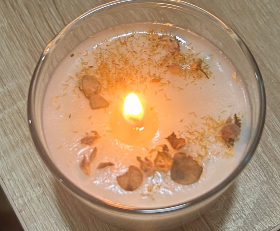 Vela de Romelia encendida, con flores secas